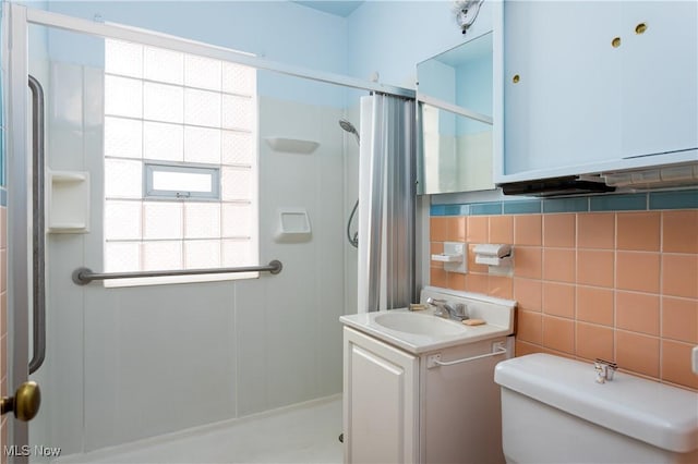 bathroom featuring tasteful backsplash, tile walls, vanity, walk in shower, and toilet