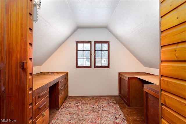 interior space featuring lofted ceiling, hardwood / wood-style floors, and a textured ceiling