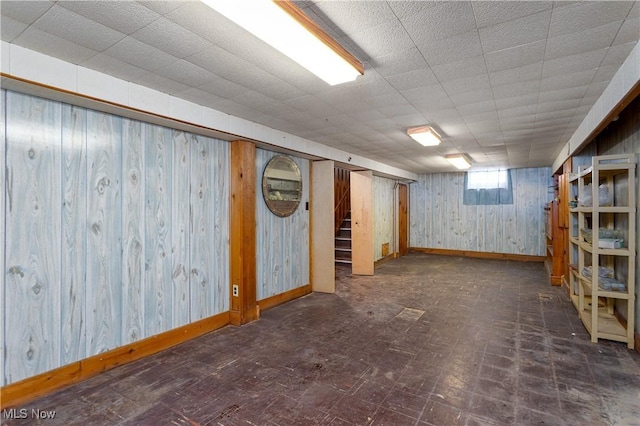 basement featuring wooden walls