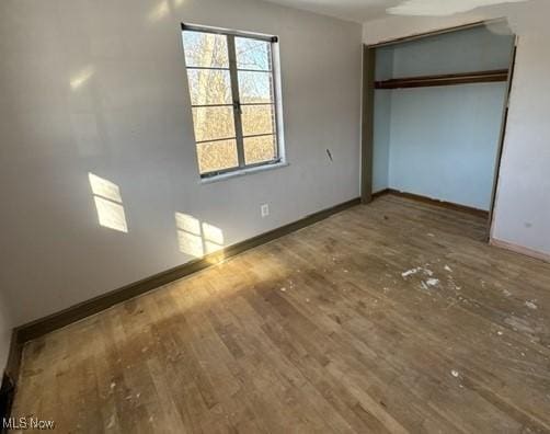 unfurnished bedroom featuring hardwood / wood-style flooring and a closet