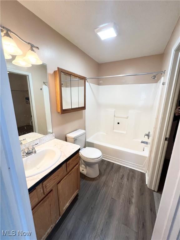 full bathroom featuring washtub / shower combination, vanity, toilet, and hardwood / wood-style floors