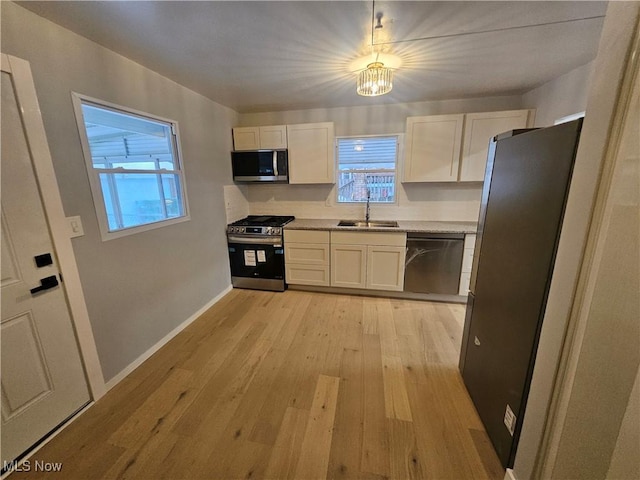 kitchen with white cabinetry, sink, stainless steel appliances, and light wood-type flooring