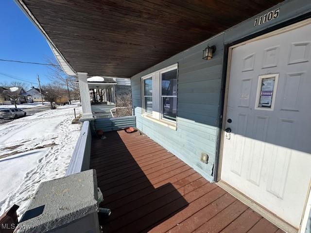 snow covered deck with covered porch