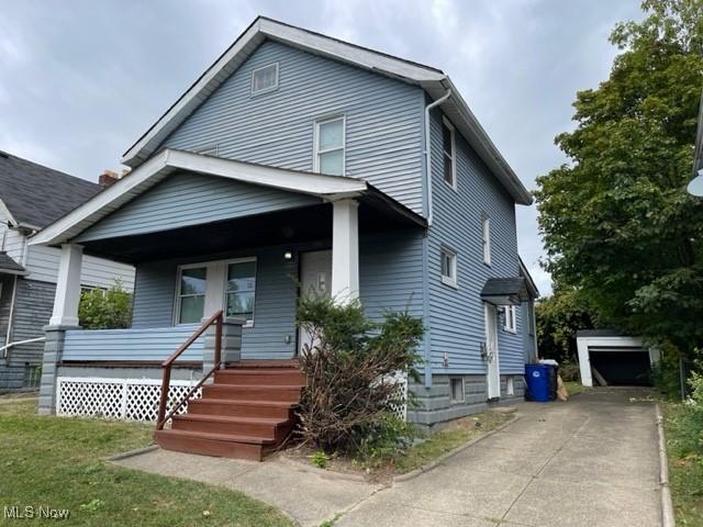 view of front facade featuring a garage, an outbuilding, and covered porch