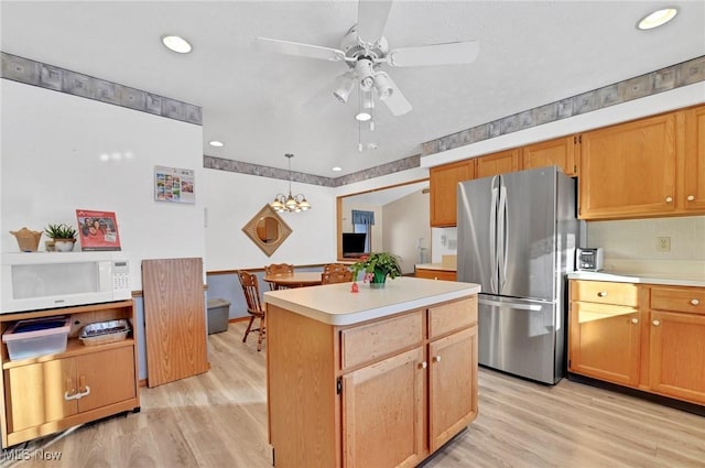 kitchen with pendant lighting, light hardwood / wood-style floors, stainless steel refrigerator, and a center island