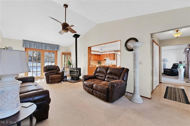 carpeted living room featuring ceiling fan, lofted ceiling, and a wood stove