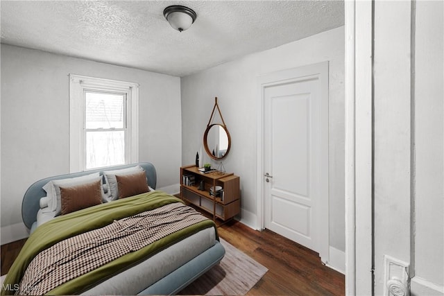 bedroom with dark wood-type flooring and a textured ceiling