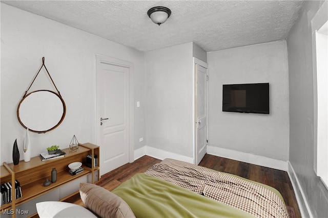 bedroom with dark hardwood / wood-style flooring and a textured ceiling