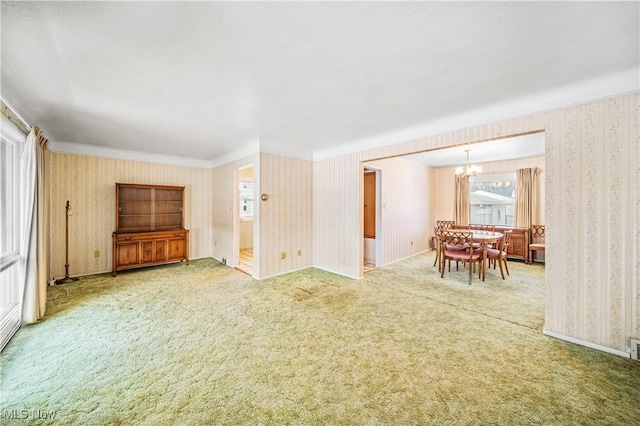 unfurnished living room featuring carpet floors and a chandelier