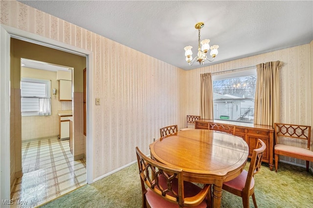 dining area featuring an inviting chandelier and a textured ceiling