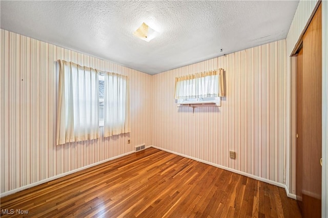 unfurnished room featuring hardwood / wood-style floors and a textured ceiling