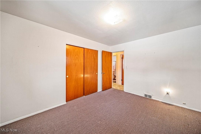 unfurnished bedroom with carpet floors and a closet