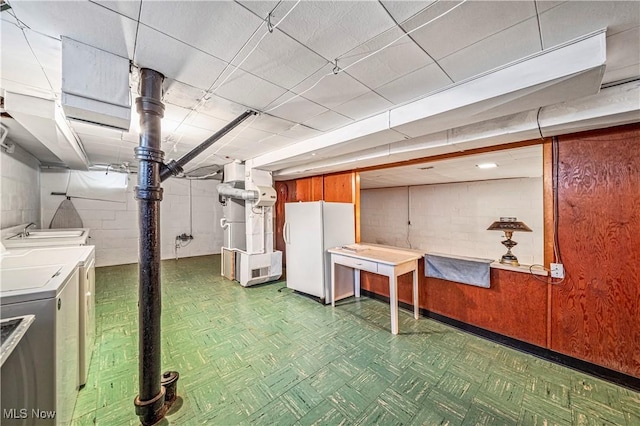 basement with washer and dryer and white refrigerator