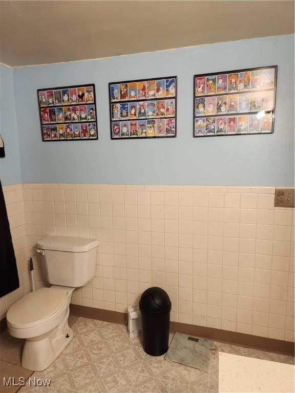 bathroom with tile walls and toilet