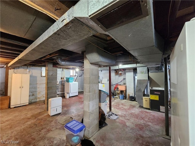 basement featuring heating unit and washer and clothes dryer