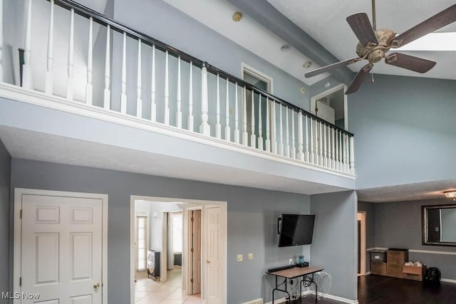 stairway with ceiling fan and a towering ceiling