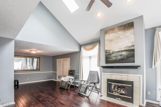 living area featuring hardwood / wood-style flooring, lofted ceiling, a wealth of natural light, and a fireplace