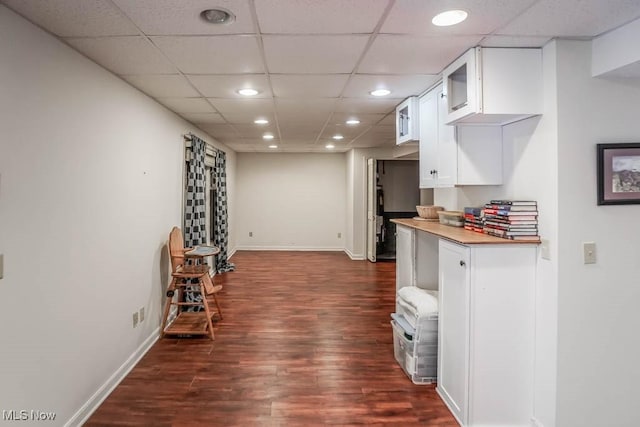 kitchen with white cabinetry, a drop ceiling, and dark hardwood / wood-style flooring