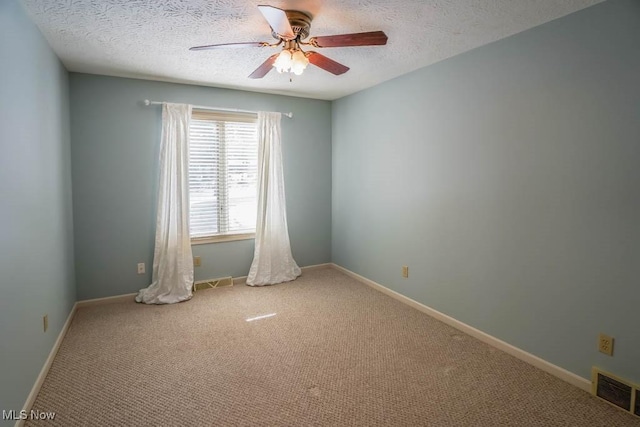 spare room featuring ceiling fan, a textured ceiling, and carpet