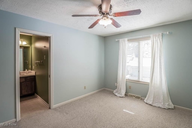 carpeted empty room with ceiling fan and a textured ceiling