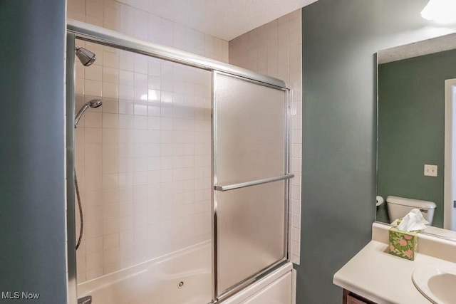 full bathroom featuring vanity, shower / bath combination with glass door, and toilet