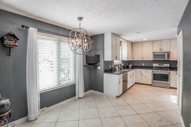 kitchen featuring light tile patterned flooring, decorative light fixtures, sink, stainless steel appliances, and an inviting chandelier