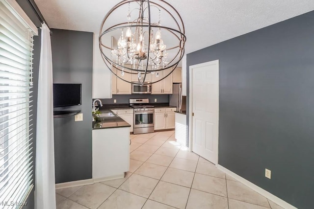 kitchen with pendant lighting, sink, light tile patterned floors, appliances with stainless steel finishes, and a chandelier