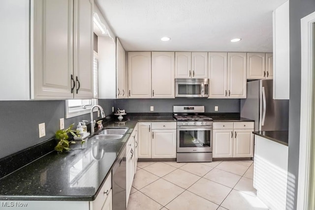 kitchen featuring white cabinets, stainless steel appliances, sink, and light tile patterned floors