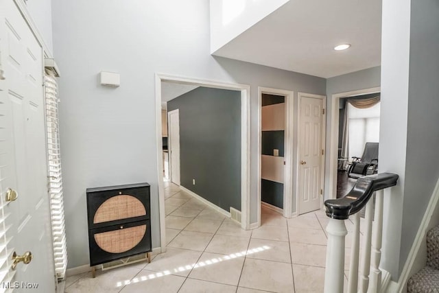 corridor featuring light tile patterned floors and baseboards