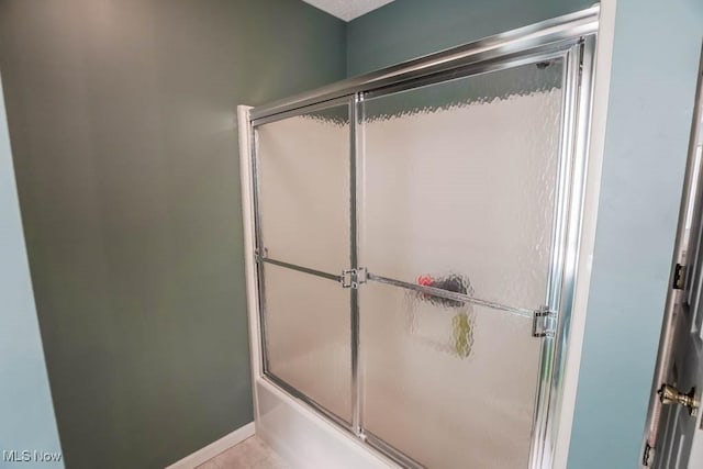 bathroom featuring bath / shower combo with glass door