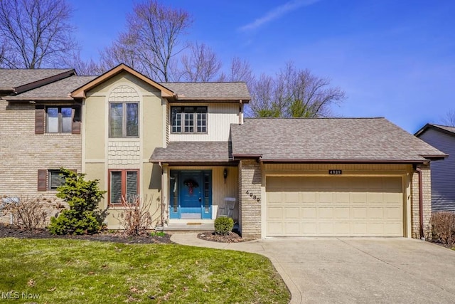 traditional home with a front lawn, driveway, a shingled roof, a garage, and brick siding