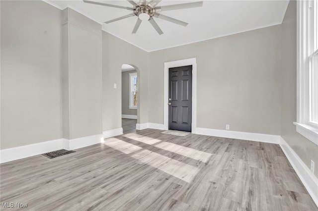 unfurnished room featuring light hardwood / wood-style flooring, ornamental molding, ceiling fan, and vaulted ceiling