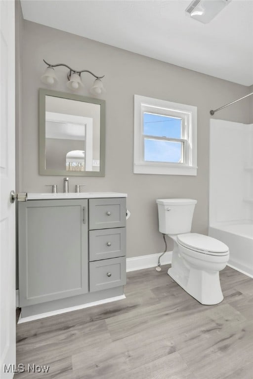 full bathroom featuring vanity, hardwood / wood-style floors, toilet, and shower / bath combination