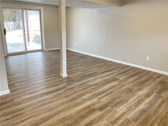 basement featuring wood finished floors and baseboards