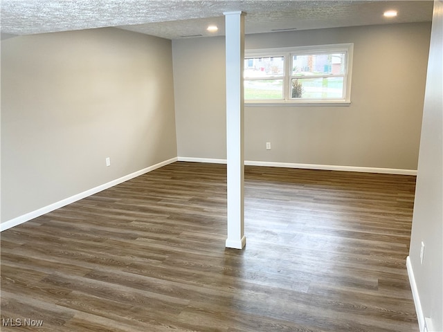 basement featuring dark wood-type flooring and a textured ceiling