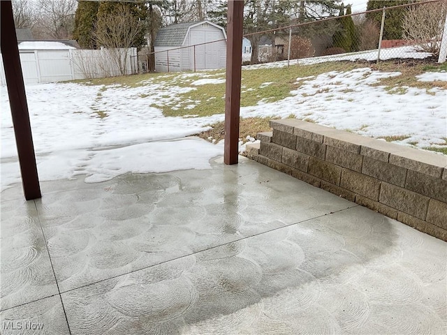 snow covered patio with a shed