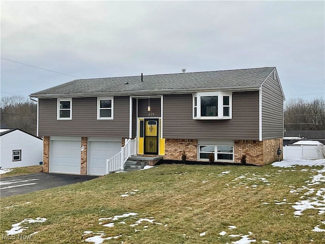 bi-level home featuring a garage and a front yard