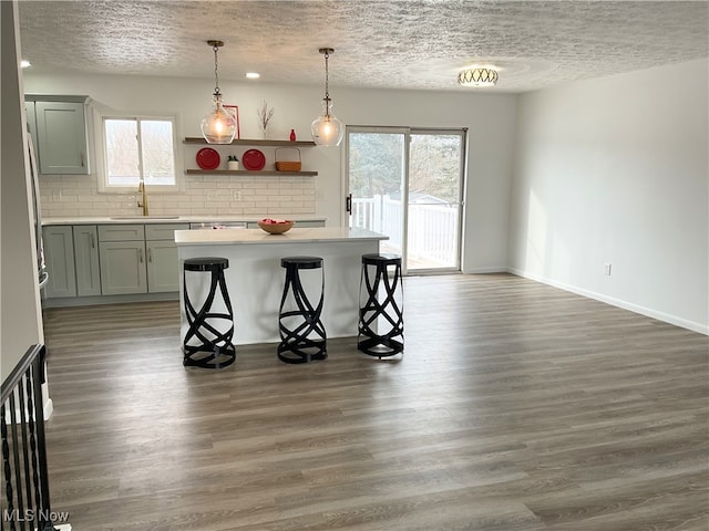 kitchen with dark hardwood / wood-style flooring, sink, and a kitchen breakfast bar