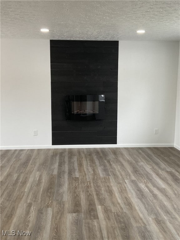 details with a large fireplace, hardwood / wood-style floors, and a textured ceiling