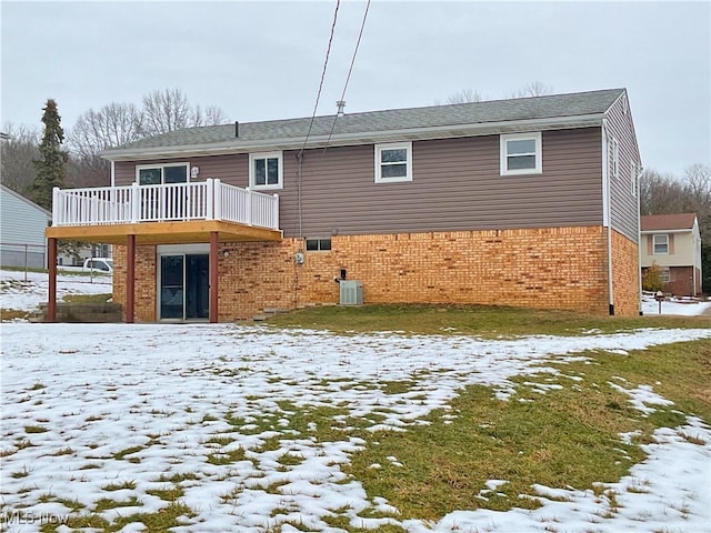 snow covered property with cooling unit and a deck