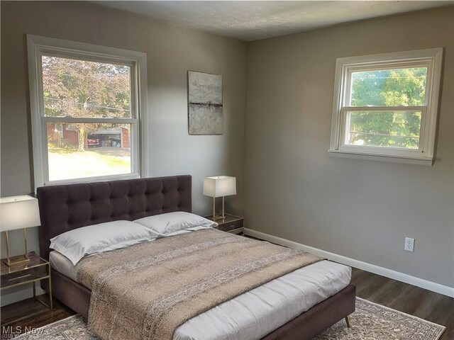 bedroom with baseboards and wood finished floors