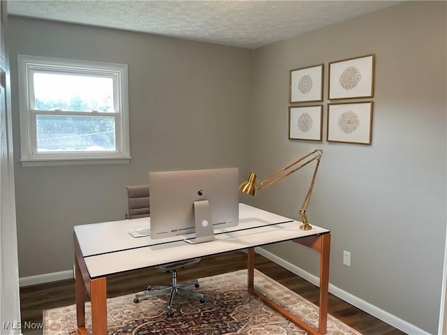 home office featuring dark wood-type flooring, baseboards, and a textured ceiling