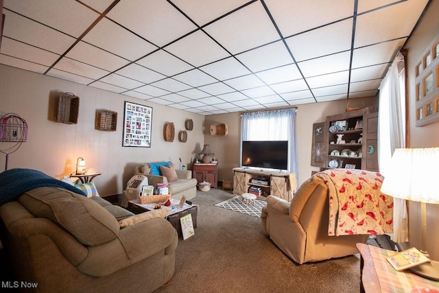 carpeted living room featuring a drop ceiling