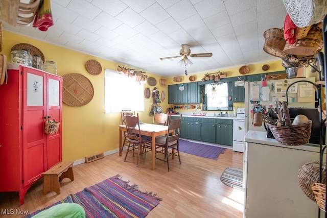 kitchen featuring ceiling fan, sink, light wood-type flooring, and electric range