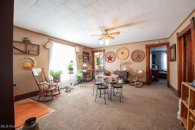 carpeted dining room with ceiling fan