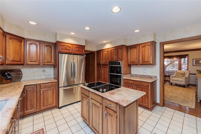 kitchen with a kitchen island, backsplash, light tile patterned floors, light stone counters, and stainless steel appliances