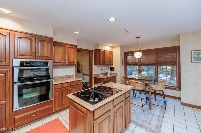 kitchen featuring a kitchen island, decorative light fixtures, black electric stovetop, light tile patterned floors, and stainless steel double oven