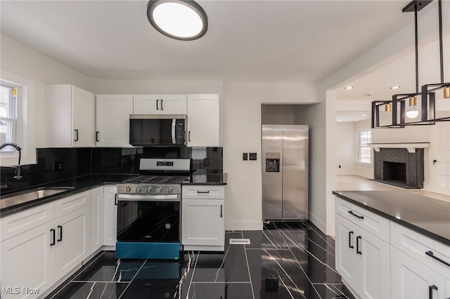 kitchen with pendant lighting, white cabinetry, appliances with stainless steel finishes, and sink