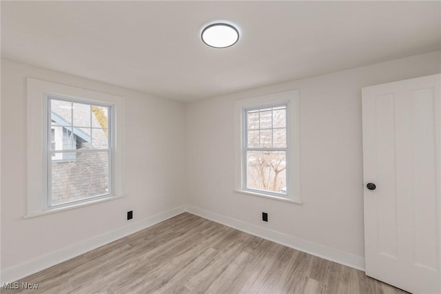 spare room with a healthy amount of sunlight and light hardwood / wood-style flooring