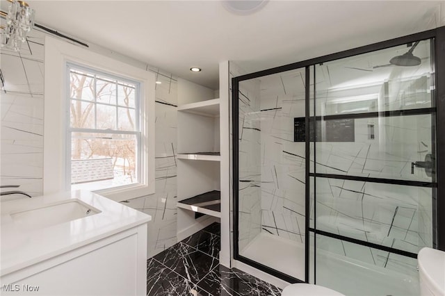 bathroom with vanity, toilet, and a shower with door